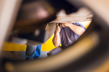 Photo of car mechanics fixing the car. Inside the car shop