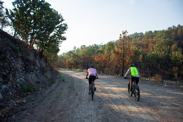 two people biking on a path in the mountain