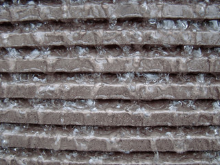 Background. Flowing water on a granite ribbed wall. Bubbles.