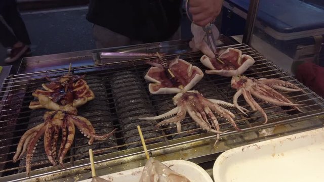 Market in Taiwan serving squid on a grill.