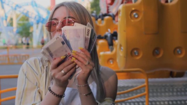 girl waving money joyful rich