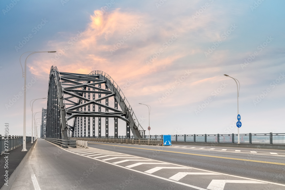 Wall mural steel bridge and road with sunset sky