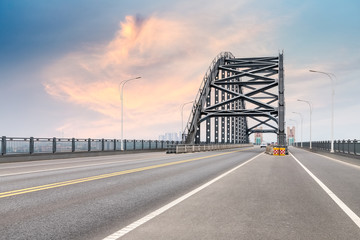 steel bridge and road with dusk sky