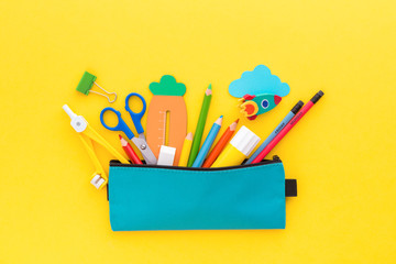 Back to school concept. Pencil case with school supplies on yellow background. - obrazy, fototapety, plakaty