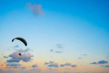 paraglider flying on sky at sunset
