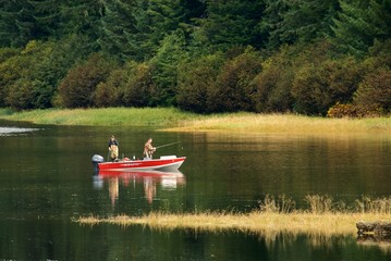 Fototapeta na wymiar Fishing in a boat inside a lake in nature nice landscape Alaska