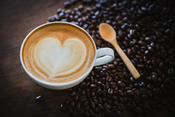 cup of coffee and coffee beans  on dark background, top view