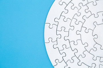  white jigsaw puzzle pieces on blue background,  Copy space.