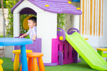 Little Asian boy playing slider at playground kindergarten school