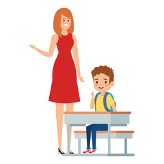 student boy seated in school desk with female teacher