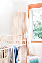 Mosquito net in a modern bedroom with a baby bed