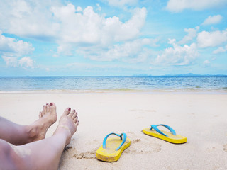 Woman selfie barefoot and yellow sandals on the beach.