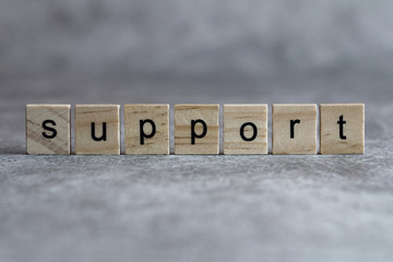 Support word written on wood cube
