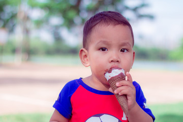 close up portriat asian cute little children eating ice-cream are happiness  and funny in park at thailand