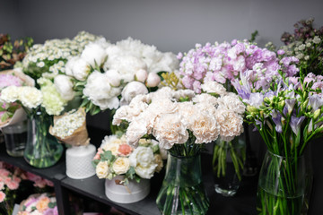 Vases with different colored flowers, showcase flower shop. Beautiful spring bouquets. . Small family business. Work florist. copy space