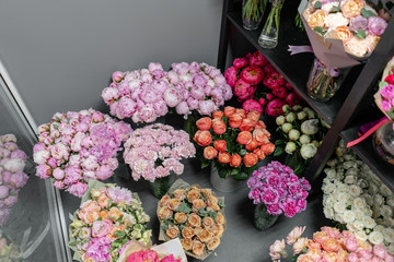 Vases with different colored flowers, showcase flower shop. Beautiful spring bouquets. . Small family business. Work florist. copy space