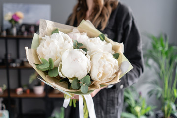 White peonies in womans hands. Beautiful fresh peony flower for catalog or online store. Floral shop concept. Flowers delivery
