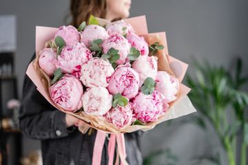 Pink peonies in womans hands. Beautiful peony flower for catalog or online store. Floral shop concept . Beautiful fresh cut bouquet. Flowers delivery © malkovkosta