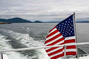 American flag flying off the back of a boat on the Salish Sea in the San Juan Islands on a stormy day