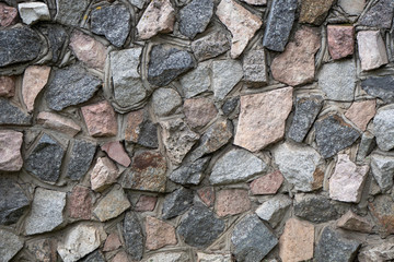 The texture of the wall of natural stone. Masonry of cement-bound cobblestones.