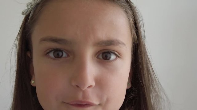 An angry young girl stares into the camera and yells in slow motion.