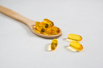omega 3 vitamins on a wooden spoon on a white background. healthy lifestyle concepthealthy...