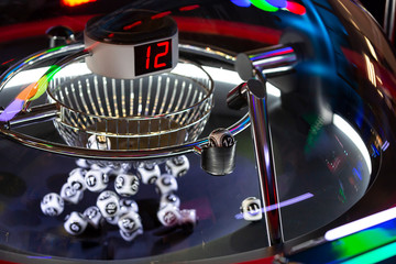 Black and white lottery balls in a rotating bingo machine. Number 12