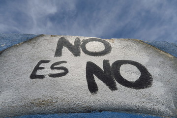 No es no. Non c'est non. Inscription féministe en espagnol sur un mur blanc avec ciel bleu.