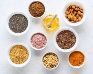 Healthy super food clean eating selection (seeds, powder turmeric, carob, nuts, honey, dried beet)