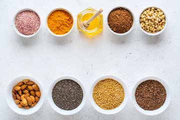Healthy super food clean eating selection (seeds, powder turmeric, carob, nuts, honey, dried beet)