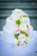 White wedding cake with real roses