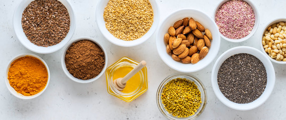 Healthy super food clean eating selection (seeds, powder turmeric, carob, nuts, honey, bee pollen,...