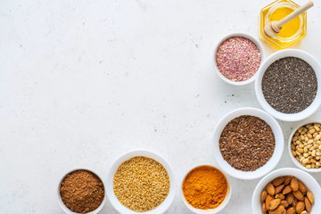 Healthy super food clean eating selection (seeds, powder turmeric, carob, nuts, honey, dried beet)