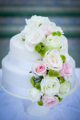 White wedding cake with real roses