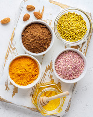 Healthy super food clean eating selection (powder turmeric, carob, nuts, honey, bee pollen, dried beet)