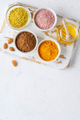 Healthy super food clean eating selection (powder turmeric, carob, nuts, honey, bee pollen, dried beet)