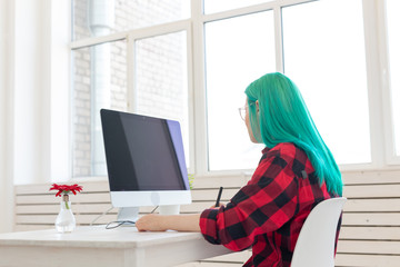 Business, designer and animator concept - young woman illustrator or artist with green hair draws...