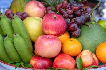 Assortment of fresh fruit banana, grapes, orange, apple, pineapple, tangerine and grapefruit on a tray. Closeup