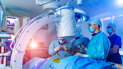 Group of surgeons in operating room with surgery equipment. Medical background