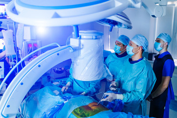 Spinal surgery. Group of surgeons in operating room with surgery equipment. Laminectomy. Modern...