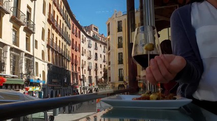 Casual everyday life in Spanish capital Madrid, woman enjoying olive tapas and wine