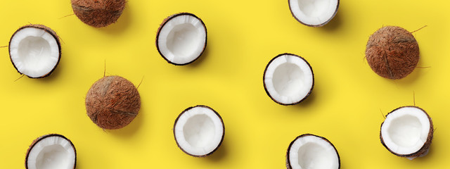 Pattern with ripe coconuts on yellow background. Pop art design, creative summer concept. Banner. Half of coconut in minimal flat lay style - obrazy, fototapety, plakaty