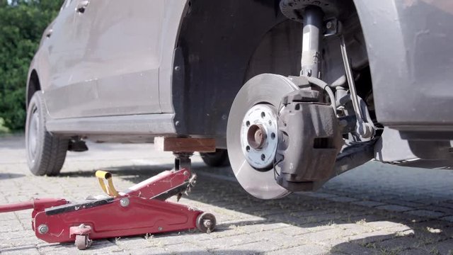 Man removes old tire from front axle to change it for the next season.