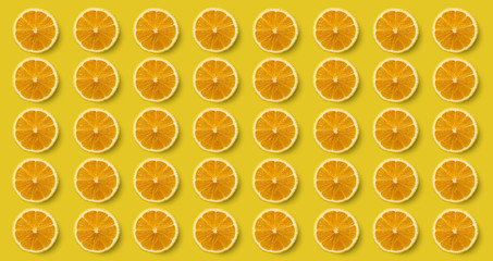 Many fresh lemon slices on a bright yellow background.