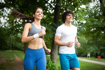 Fototapeta premium Happy young woman doing excercise outdoor in a park, jogging