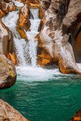 Fototapeta na wymiar Breathtaking view of beautiful waterfall of the mountain river. Sapadere canyon, Turkey. Summer vacation, rest, wild nature concept.