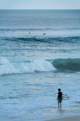 A surfer getting ready for the surf, going surfing in ocean