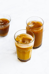 Iced coffee with cream and vanilla in various glasses on white background. Summer cocktail or dessert