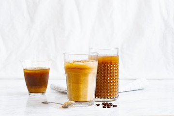 Iced coffee with cream and vanilla in various glasses on white background. Summer cocktail or dessert