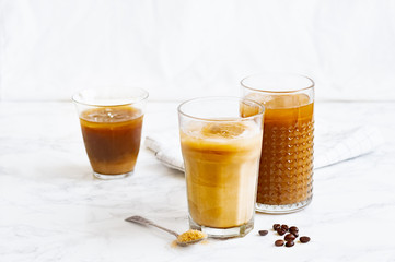 Iced coffee with cream and vanilla in various glasses on white background. Summer cocktail or dessert